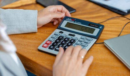 foto van hand die op een rekenmachine typt