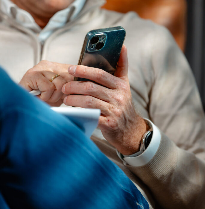Collega zoekt iets op telefoon op