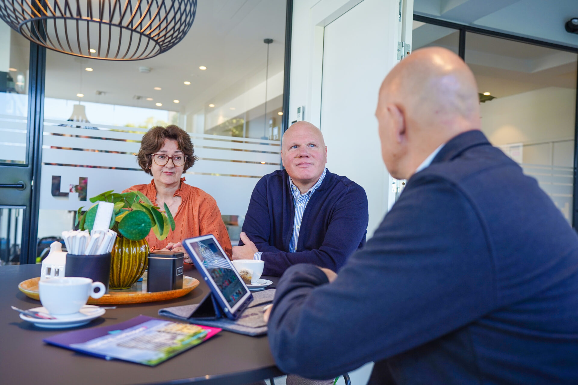 Collega met klanten aan tafel